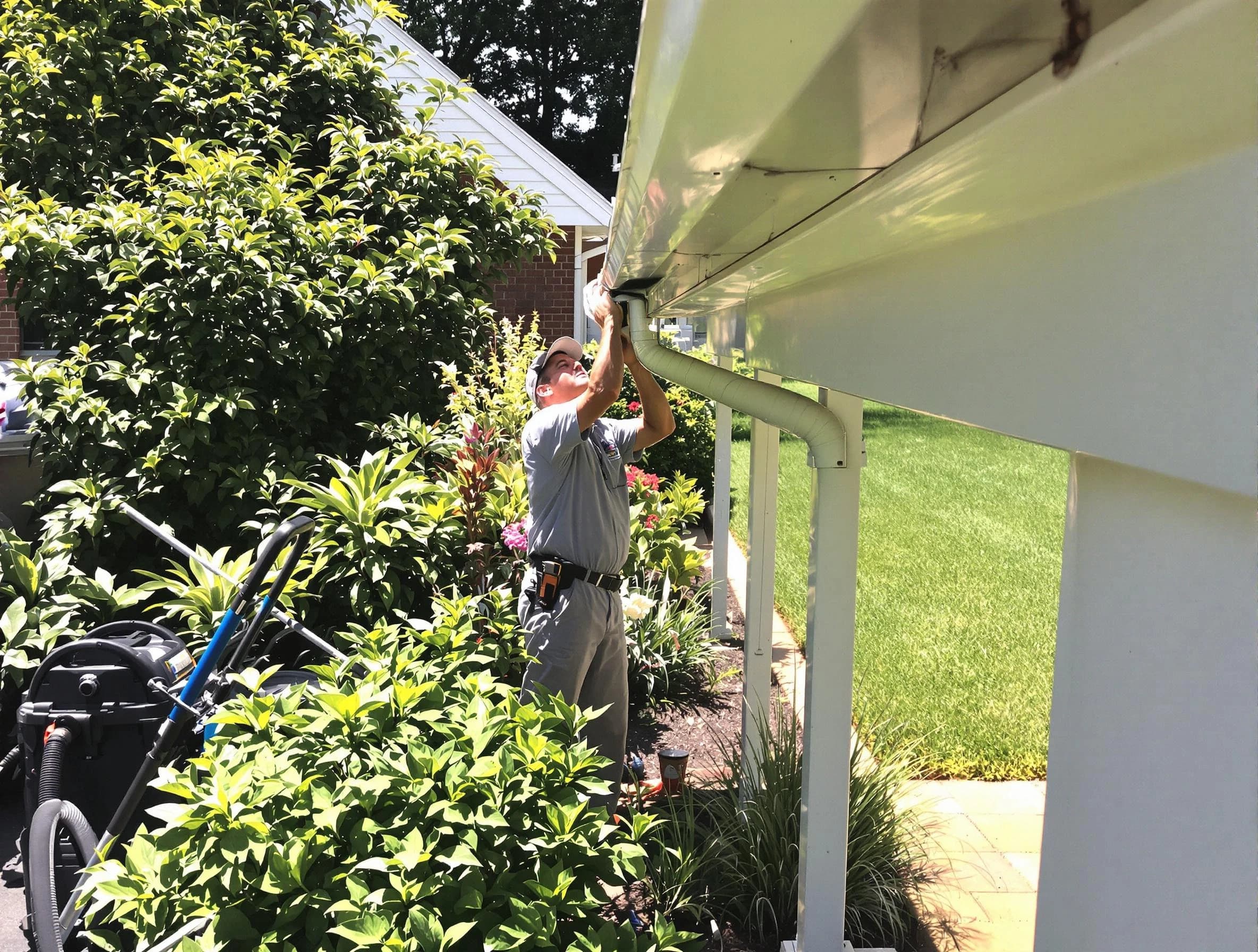 Technician flushing a blockage from a downspout in Green, OH